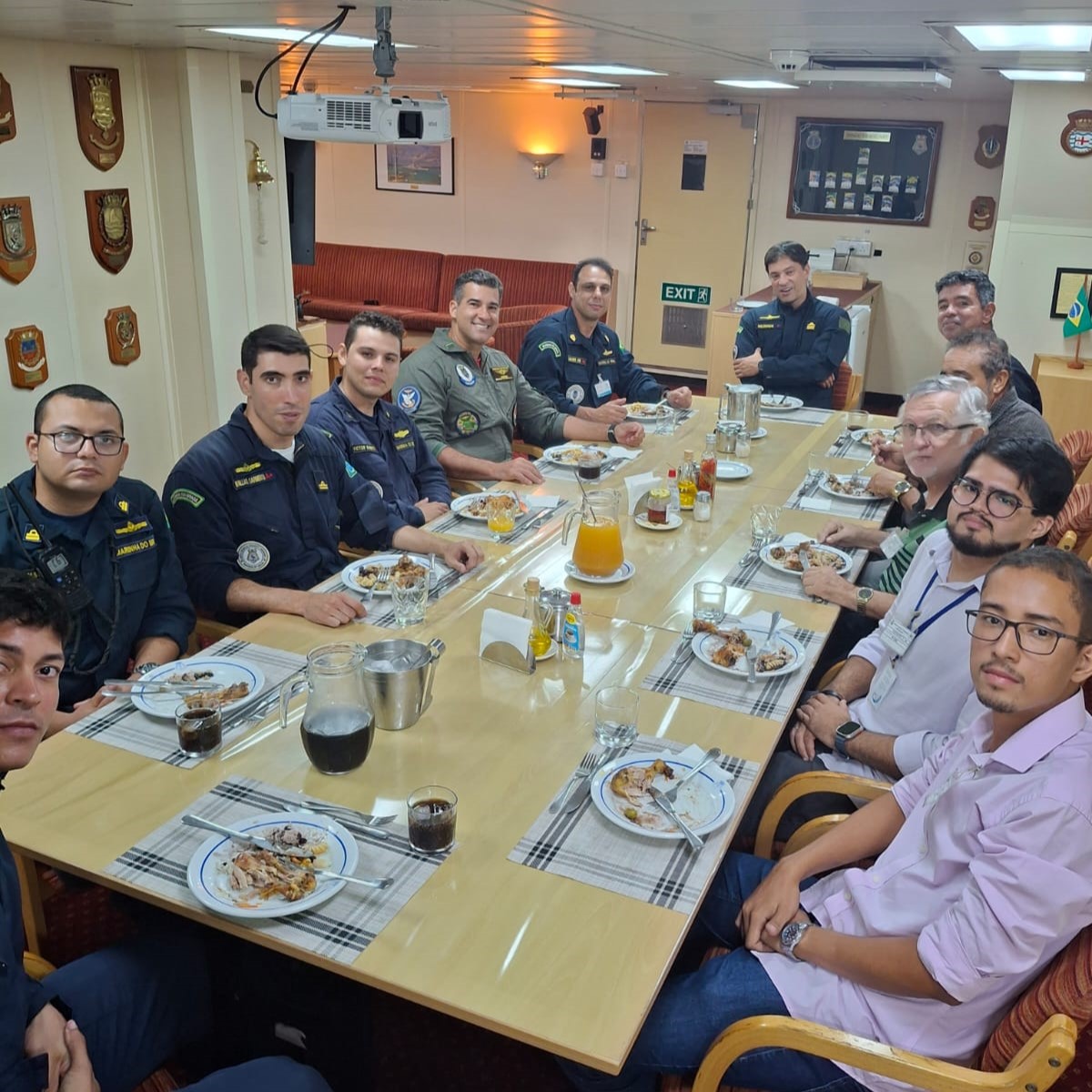 Foto da equipe na sala de estado com os oficias no momento de almoço